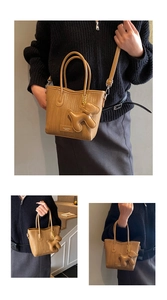 Detail of brown woven texture bucket bag with cute dog charm and adjustable strap