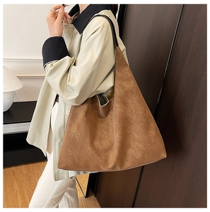 Detail view of large brown suede tote bag with slim black straps and spacious interior