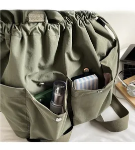 Detail view of military green nylon bucket bag showing storage capacity and functional pockets