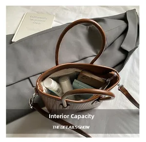 Internal capacity of contrast bucket bag showing cosmetics and adjustable strap