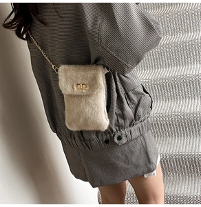 Détail du mini sac beige en fausse fourrure avec chaîne dorée et fermoir pivotant