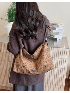 Détail d'un sac cabas léopard avec écusson logo noir et bandoulière en marron rétro