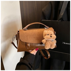 Detailansicht der dunkelbraunen Handtasche mit Wildleder-Patchwork und Teddy-Anhänger