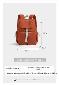 Detail view of orange polyamide backpack showing dual front pockets and large A4 capacity