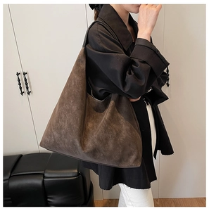 Detail of vintage matte large tote bag in dark brown faux leather on a model shoulder