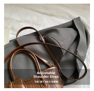 Close-up of the woven texture and adjustable shoulder strap on the brown straw handbag