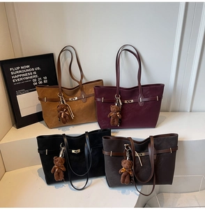 Detail of four large tote bags in camel, burgundy, black, and brown with metal locks