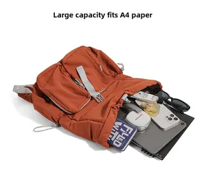 Detailed interior of a burnt orange backpack showing tablets, notebooks and accessories