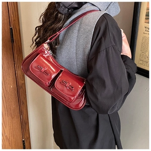 Detail of burgundy glossy patent leather baguette bag with retro bow flap pockets