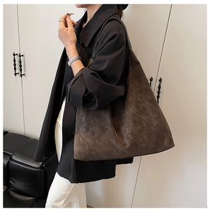 Model wearing a large dark brown matte suede hobo tote bag for daily commute fashion