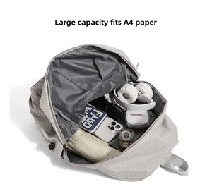Detailed interior of a grey checkered backpack showing storage for A4 files and essentials