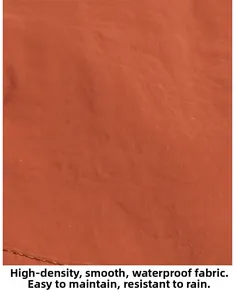 Detail of high-density waterproof orange-red fabric showing smooth texture and water resistance