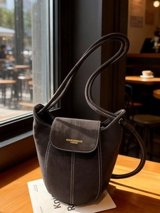 Sac seau minimaliste en daim taupe avec surpiqûres contrastées et bandoulière réglable