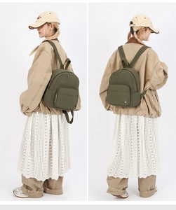 Detail view of the green nylon backpack showing the side and back on a model