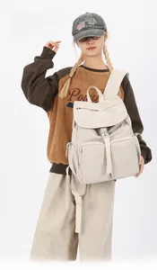 Detail of adjustable woven straps on beige nylon backpack for customizable length