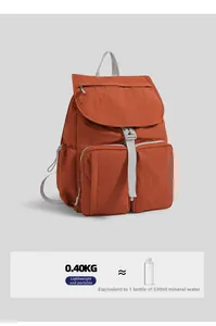 Detail of lightweight orange nylon backpack showing large zip pockets and weight comparison