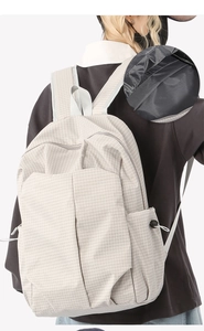 Detailed close-up of grid textured fabric and branded black interior lining of the backpack
