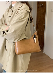 Detail of brown retro bucket bag with decorative wooden beads and leather texture