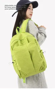 Detail of green checkered backpack featuring adjustable wide straps on a model