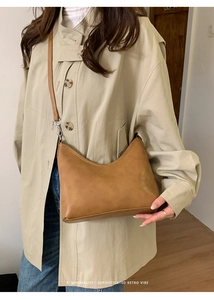 Minimalist brown retro leather hobo bag with adjustable strap worn by a model