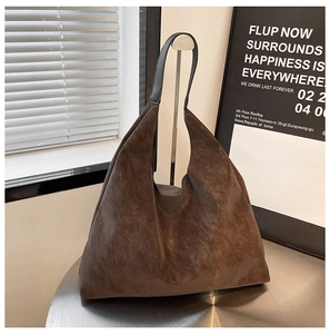 Detail view of large dark brown hobo tote bag with matte texture and black leather strap