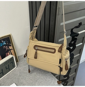 Detail of khaki canvas messenger bag with brown leather zipper and side pocket