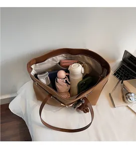 Top view of brown tote bag showing spacious interior with pockets and various personal items