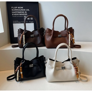 Quatre sacs à bandoulière en cuir texturé noir, café, marron et beige avec charms en bois