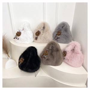 Dettaglio delle borse a secchiello in peluche in sei colori con ciondoli a gatto