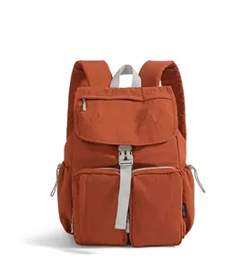 Detailed front view of a brick red waterproof nylon backpack with multiple utility pockets