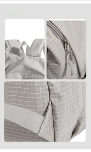 Detail view of grey plaid backpack featuring waterproof fabric and silicone zipper pulls