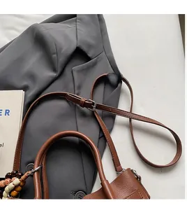 Sac seau rétro en cuir marron avec sangle en perles et bandoulière réglable vue de dessus