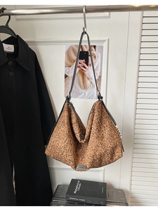 Détail du sac cabas léopard avec finition pailletée et bandoulières en cuir noir
