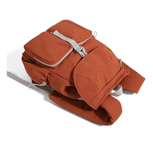 Detailed 45-degree view of caramel nylon backpack featuring double front buckled pockets