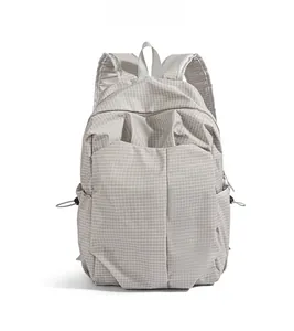 Front view of grey minimalist backpack showing square grid texture and large pocket
