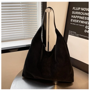 Detail view of large black faux suede hobo tote bag featuring a minimalist seamless design