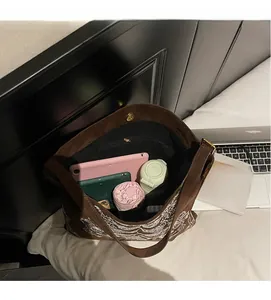 Geräumiger Innenraum der braunen Wildledertasche mit rosa Mappe, Tablet und Zubehör