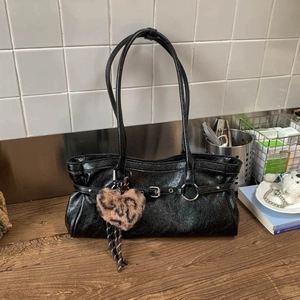 Détail du sac à bandoulière noir brillant avec boucle et breloque coeur imprimé léopard