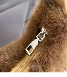 Detailed view of silver metal zipper on premium brown plush faux fur handbag material