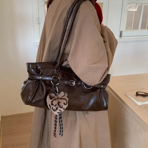 Détail du sac cabas en cuir marron brillant avec plis et charm cœur motif léopard