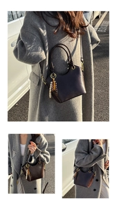 Detail of dark brown leather bucket bag with vintage beaded charm and gold hardware