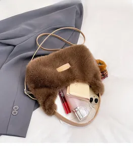 Spacious interior of brown plush crossbody bag showing phone and cosmetics
