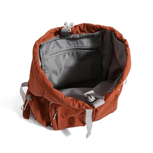 Detail of rust red backpack interior featuring honeycomb lining and secure zipper pocket