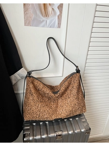 Gros plan détaillé du sac cabas à paillettes léopard avec bandoulière en cuir noir