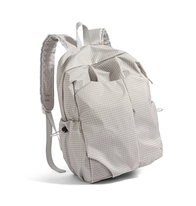 Detail of light grey checkered backpack featuring water-resistant nylon and side drawstring pocket