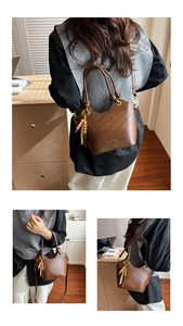 Detail view of a vintage dark brown bucket bag with colorful wood bead pendant and strap