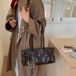 Détail du sac à bandoulière en cuir verni marron avec breloque cœur léopard