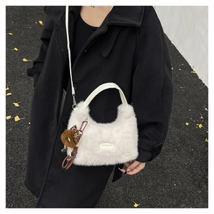 Detailed macro of white faux fur handbag with love every day tag and plush pom charm
