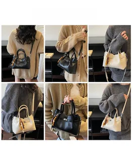 Détail du sac seau avec fermoir rotatif en métal et ornement de pompon en perles