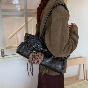 Détail du sac fourre-tout en cuir brillant noir avec boucles et charme cœur léopard